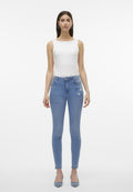 Skinny Jeans aus hellblauem Denim mit floralem Stickdetails am Oberschenkel, getragen mit einem weißen, figurbetonten Tanktop und hellblauen Absatzschuhen.