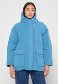 Blaue Fleecejacke mit Kapuze, Fronttaschen und strukturierter Oberfläche. Das Design enthält Knopf-Akzente und einen lässigen Schnitt.