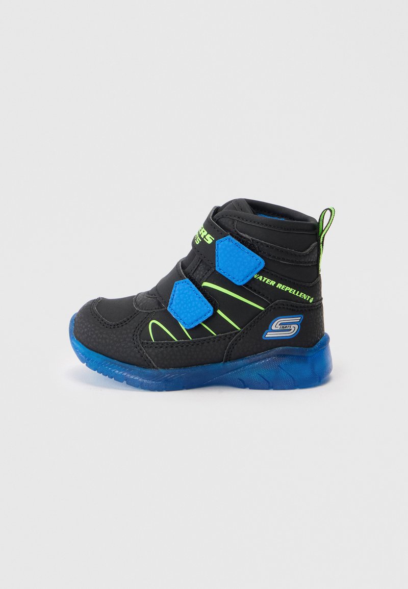 Schwarze und blaue Kinder-Hochschuhe mit neongrünen Akzenten, zwei blauen Klettverschlussriemen und einer durchsichtigen blauen Sohle.