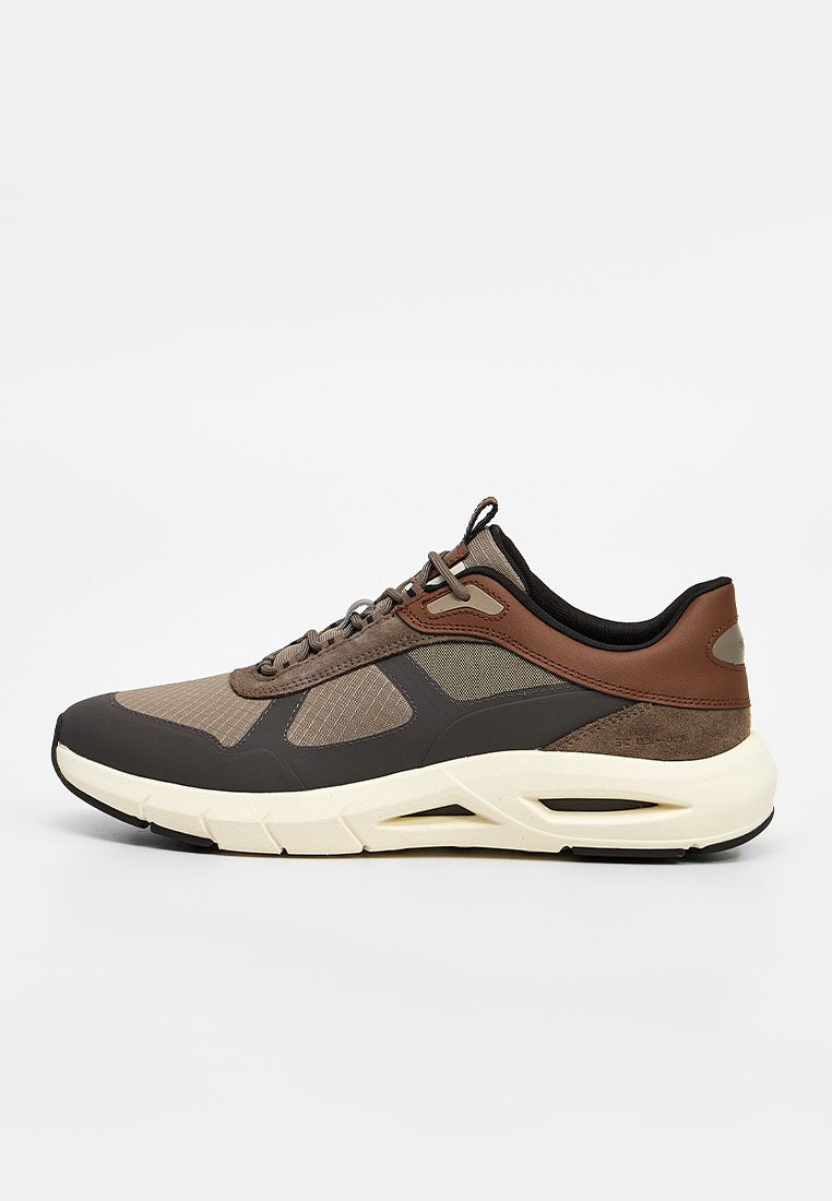 Low-Top-Sneaker in Braun, Beige und Schwarz mit Mesh- und Leder-Einsätzen, dicker weißer Sohle und Schnürverschluss.