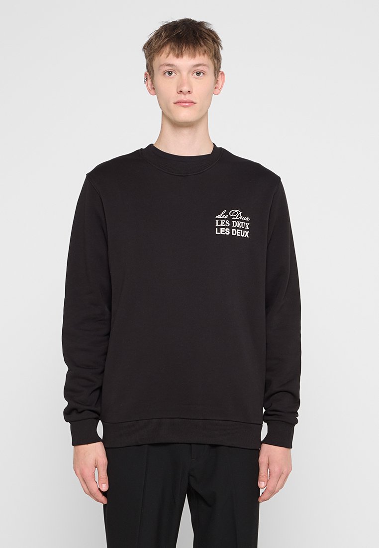 Schwarzer Sweatshirt aus Baumwolle mit Rundhalsausschnitt, gerippten Bündchen und einem kleinen, weißen, gestickten Logo auf der linken Brust.