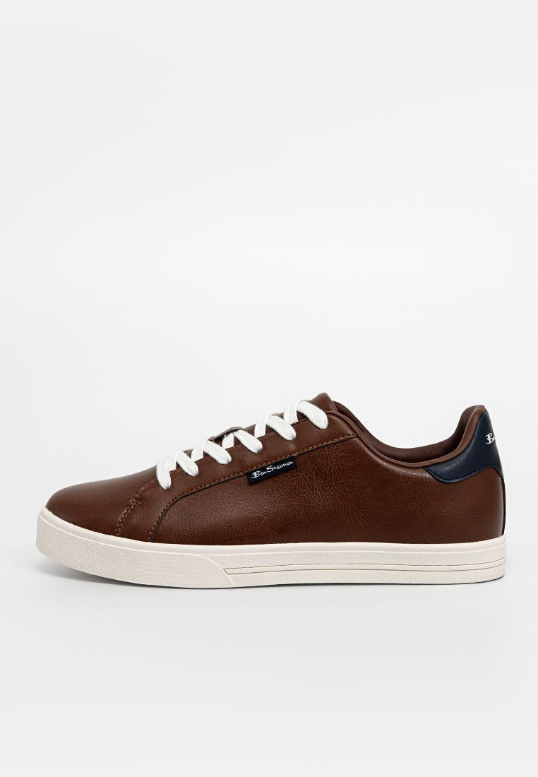 Braune Leder-Sneaker mit weißen Schnürsenkeln, niedrigem Design, strukturiertem Obermaterial, marineblauen Akzenten und einer beigefarbenen Gummisohle.