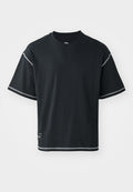 Schwarzes T-Shirt in lockerer Passform, aus Baumwolle. Mit kurzen Ärmeln, rundem Ausschnitt und kontrastierendem weißen Nähten entlang der Schultern und dem Saum.