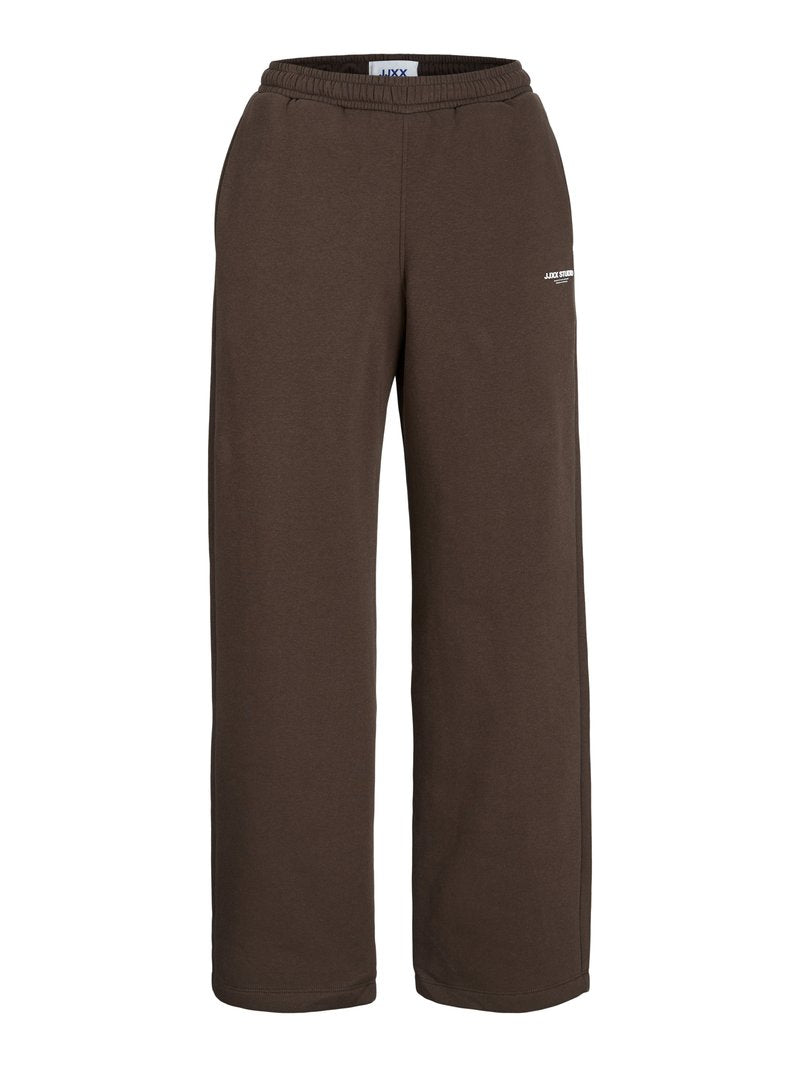 Braune Sweatpants mit weitem Bein, elastischem Bund und kleinem weißem Textlogo am oberen Oberschenkel vor weißem Hintergrund.