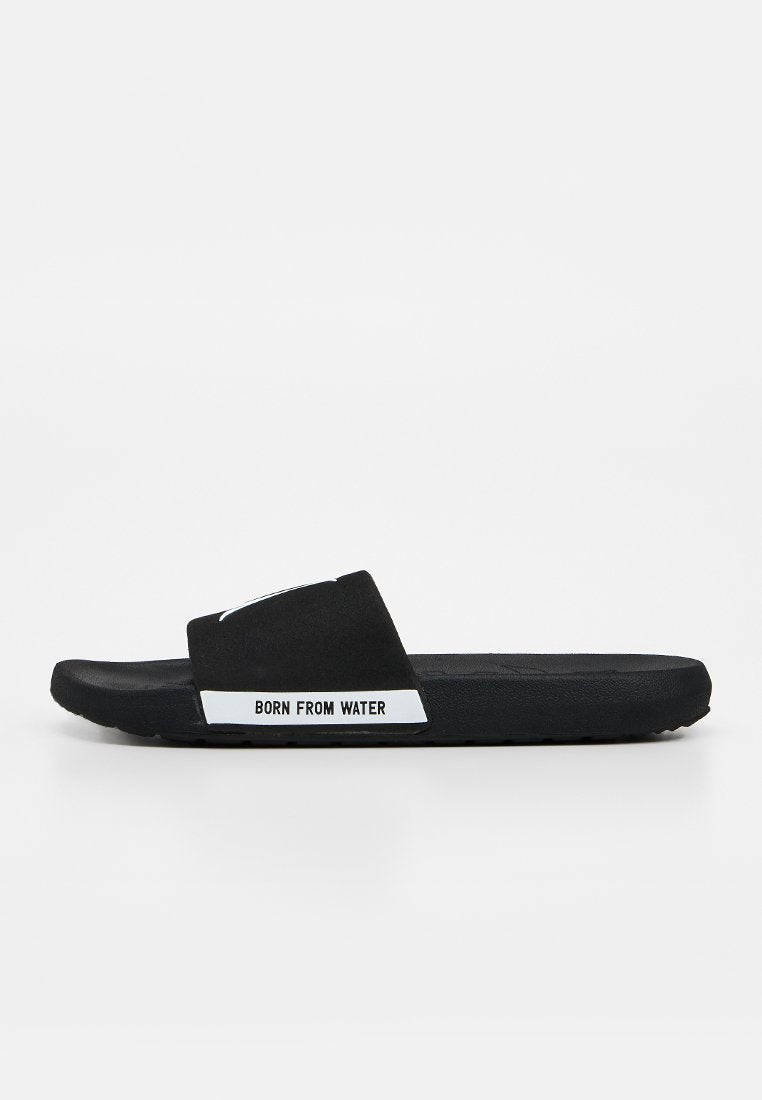 Schwarze Slide-Sandale mit breitem Riemen und weißem Text "BORN FROM WATER" an der Seite, seitlich vor neutralem Hintergrund dargestellt.