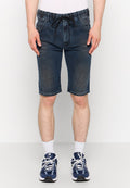 Dunkelblaue Jeansshorts mit einem Kordelzugbund, Fronttaschen und einem geraden Beinansatz, der knapp oberhalb des Knies endet. Kombiniert mit Sportschuhen.