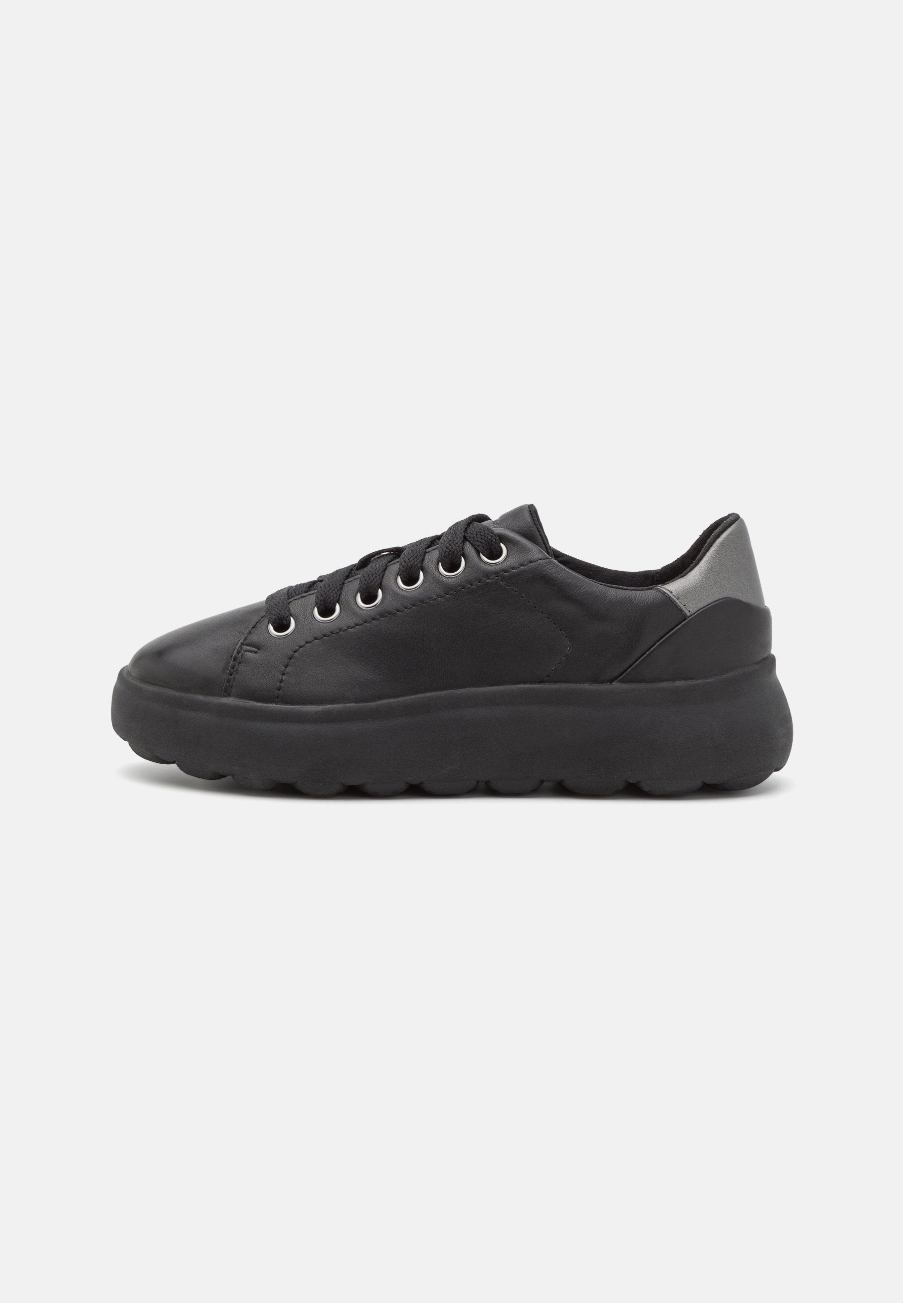 Schwarze Sneaker mit einem glatten Lederobermaterial, runder Zehenform, sechs Metallösen und einer dicken Gummisohle mit strukturierter Oberfläche. Silberner Absatzakzent.