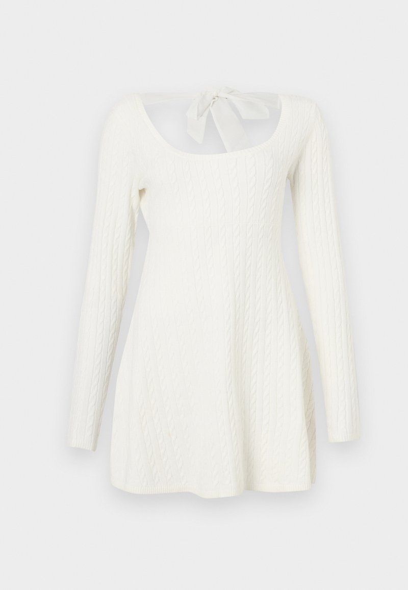 Weißes, langärmliges Strickkleid mit Zopfmuster, offenem Rücken und einer Schleife am Kragen. A-Linien-Silhouette.