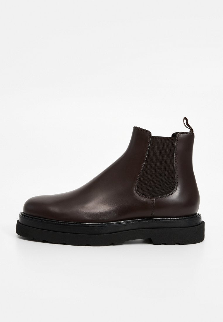 Braune Chelsea-Stiefel aus Leder mit elastischen Seitenteilen, runder Spitze und einer dicken schwarzen Gummisohle. Verfügen über eine Schlaufe zum einfachen Anziehen.