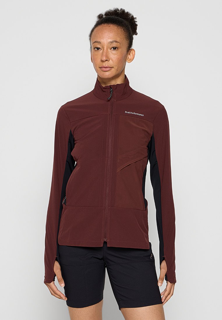 Bordeauxrote Softshelljacke mit hohem Kragen, Reißverschluss vorne und schwarzen Seitenpanels. Verfügt über eine Brusttasche und eine taillierte Passform.
