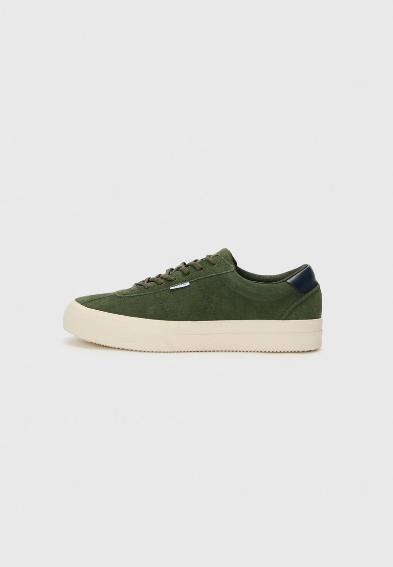 Grüne Wildledersneaker mit strukturiertem Finish, cremfarbener Gummisohle und dunkelblauem Fersenelement. Mit flachen Schnürsenkeln und runder Zehenpartie.