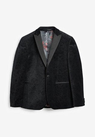 Schwarzer Blazer mit strukturiertem Obermaterial und satinierter Revers, der ein Blumenmuster aufweist. Das Innere ist rot gemustert und verfügt über zwei seitliche Taschen.