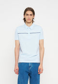 Junger Mann trägt ein hellblaues kurzärmeliges Poloshirt mit horizontalen Streifen, kombiniert mit blauen Jeans, steht vor einem einfarbigen Hintergrund.