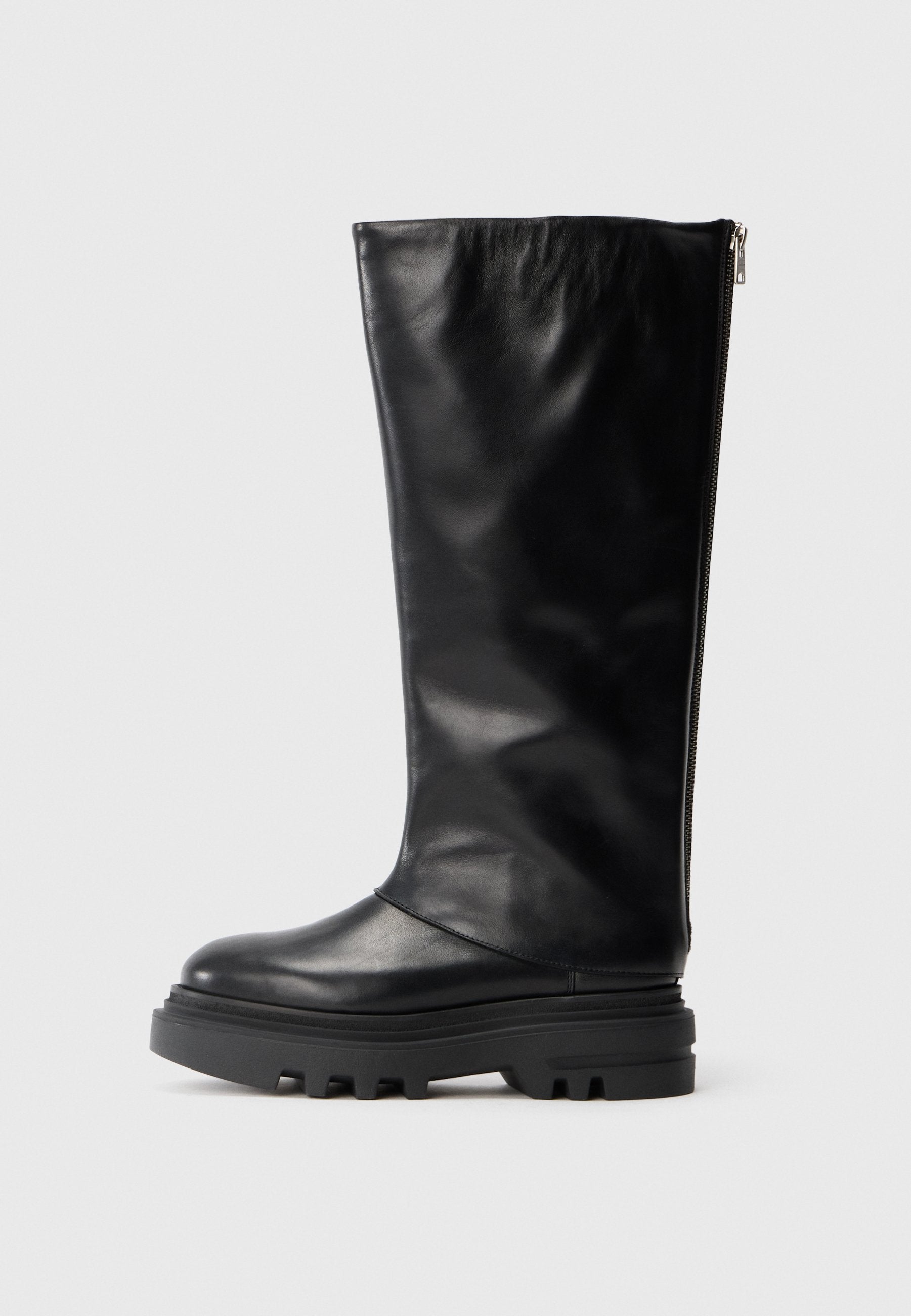 Schwarze Lederkniehohe Stiefel mit runder Zehenpartie, grober Gummisohle und einem seitlichen Reißverschluss zum Schließen. Glatte Textur mit minimaler Verzierung.