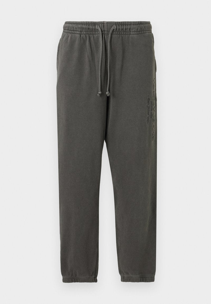 Dunkelgraue Baumwoll-Sweatpants mit elastischem Bund, Kordelzug, Seitentaschen und subtilen vertikalen Grafiken am rechten Oberschenkel.