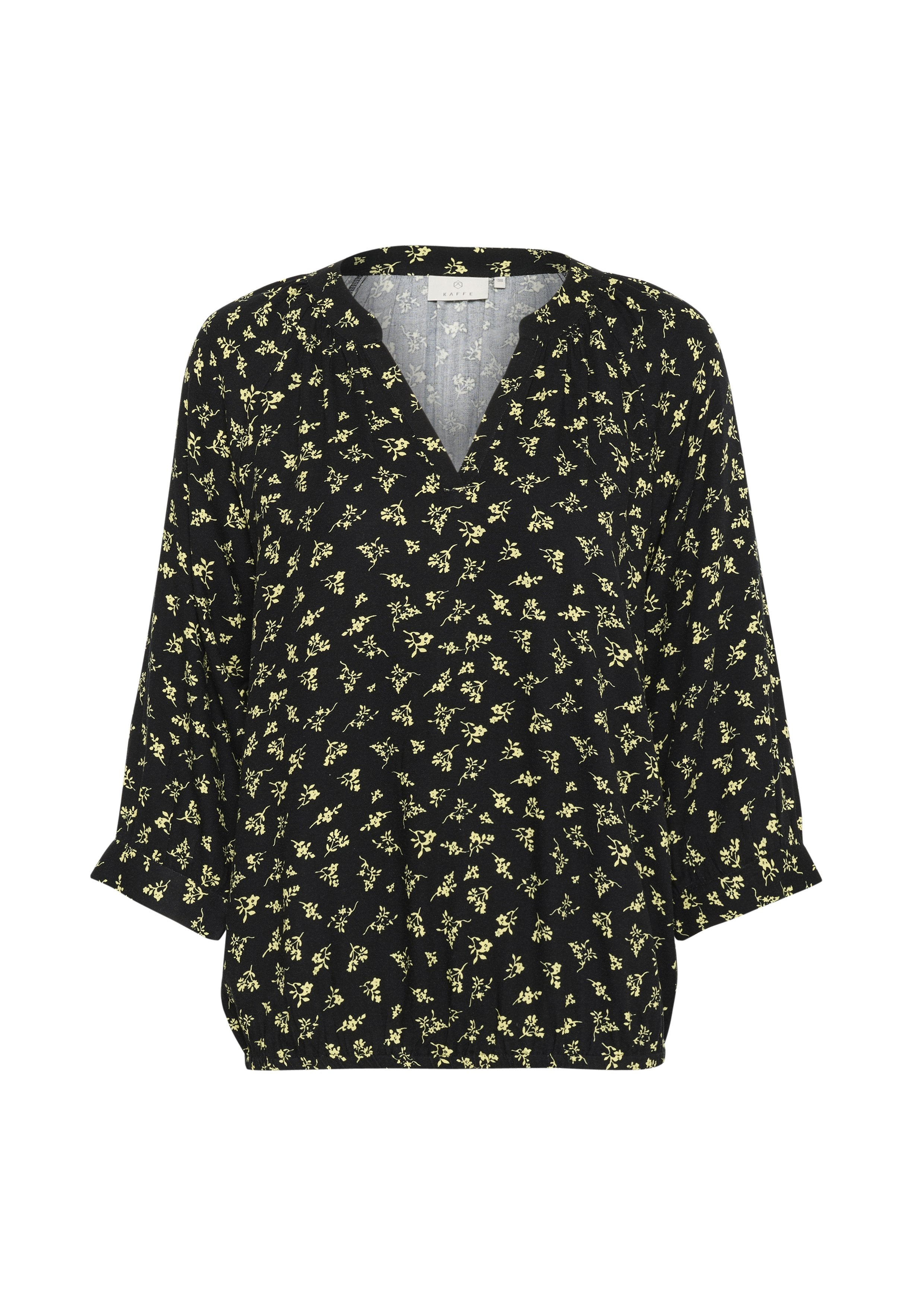 Schwarze Bluse mit V-Ausschnitt, mit einem floralen Muster in Gelb. Die Ärmel sind dreiviertellang und leicht gerafft am Saum.