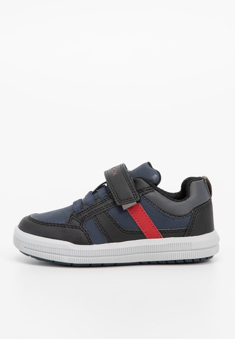 Schwarze und marineblaue Sneaker mit einem roten Akzentstreifen, Klettverschluss, strukturiertem Synthetik-Obermaterial und Gummisohle mit Rillenmuster.