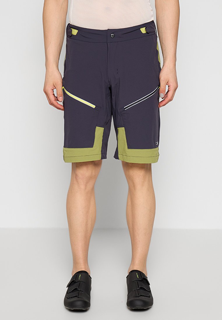 Kurze, marineblaue Shorts mit grünen Akzenten, mehreren Reißverschlusstaschen und einem atmungsaktiven Stoff. Verfügt über einen flachen Bund und kontrastierende Besätze.