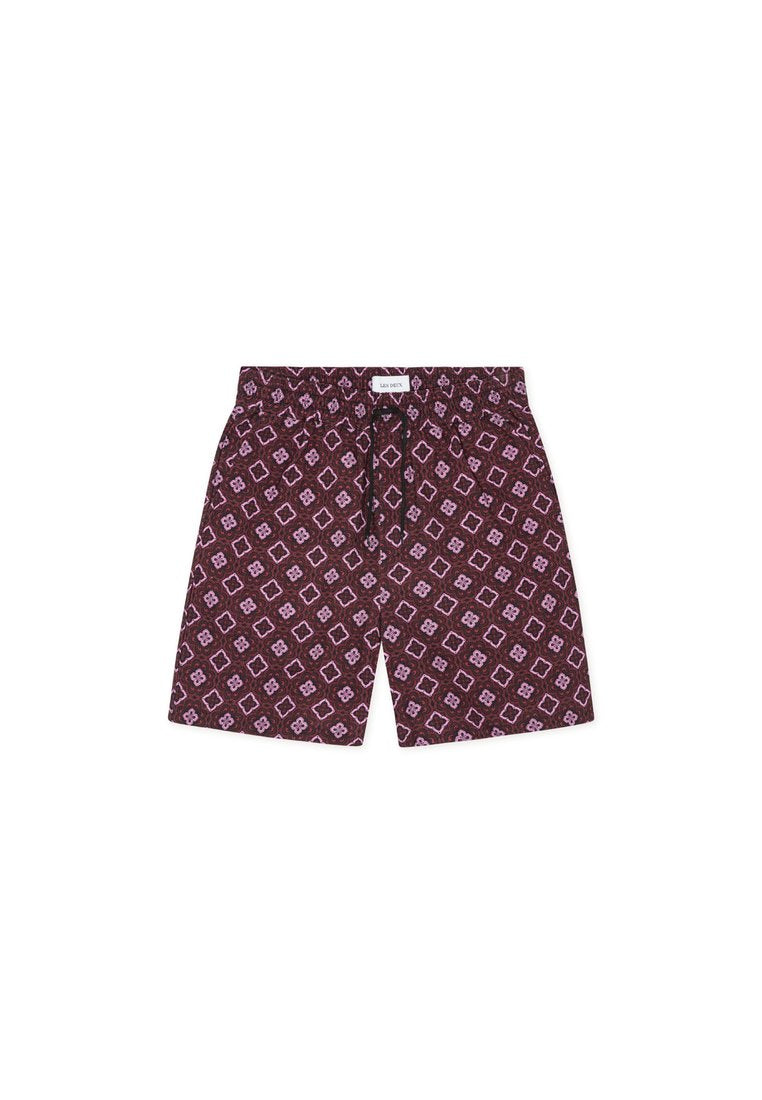Bordeauxfarbene Badeshorts mit einem geometrischen Muster in Lavendel. Elastischer Bund mit Kordelzug und Seitentaschen. Leichtes Material.