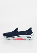Marineblauer Skechers Sportschuh zum Hineinschlüpfen mit weißer Sohle, pinker Bogenpolsterung und strukturiertem Strickobermaterial.