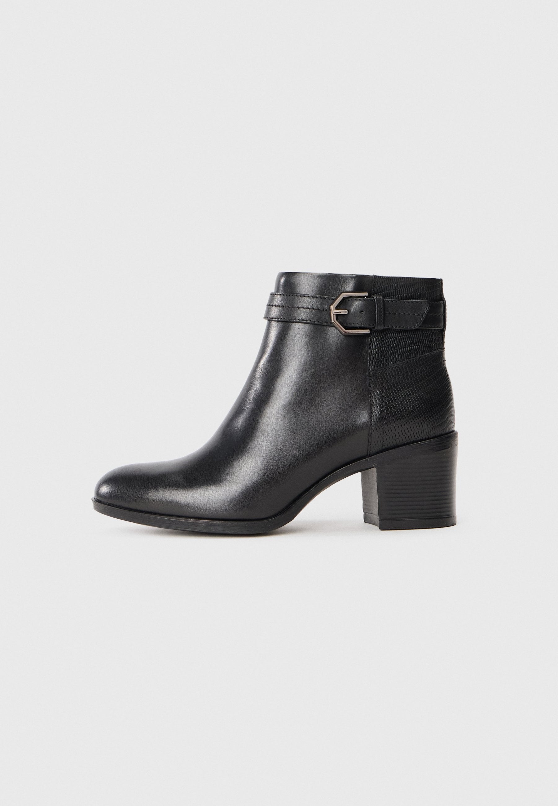 Schwarze Leder-Stiefelette mit runder Zehe, kurzem Blockabsatz und dekorativem Schnallen-Detail. Besitzt seitliche Elastikeinsätze für zusätzlichen Komfort.