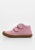 Rosa Veloursleder-Kinderhalbschuh mit zwei verstellbaren Klettverschlüssen und brauner Gummisohle, in Seitenansicht vor weißem Hintergrund gezeigt.