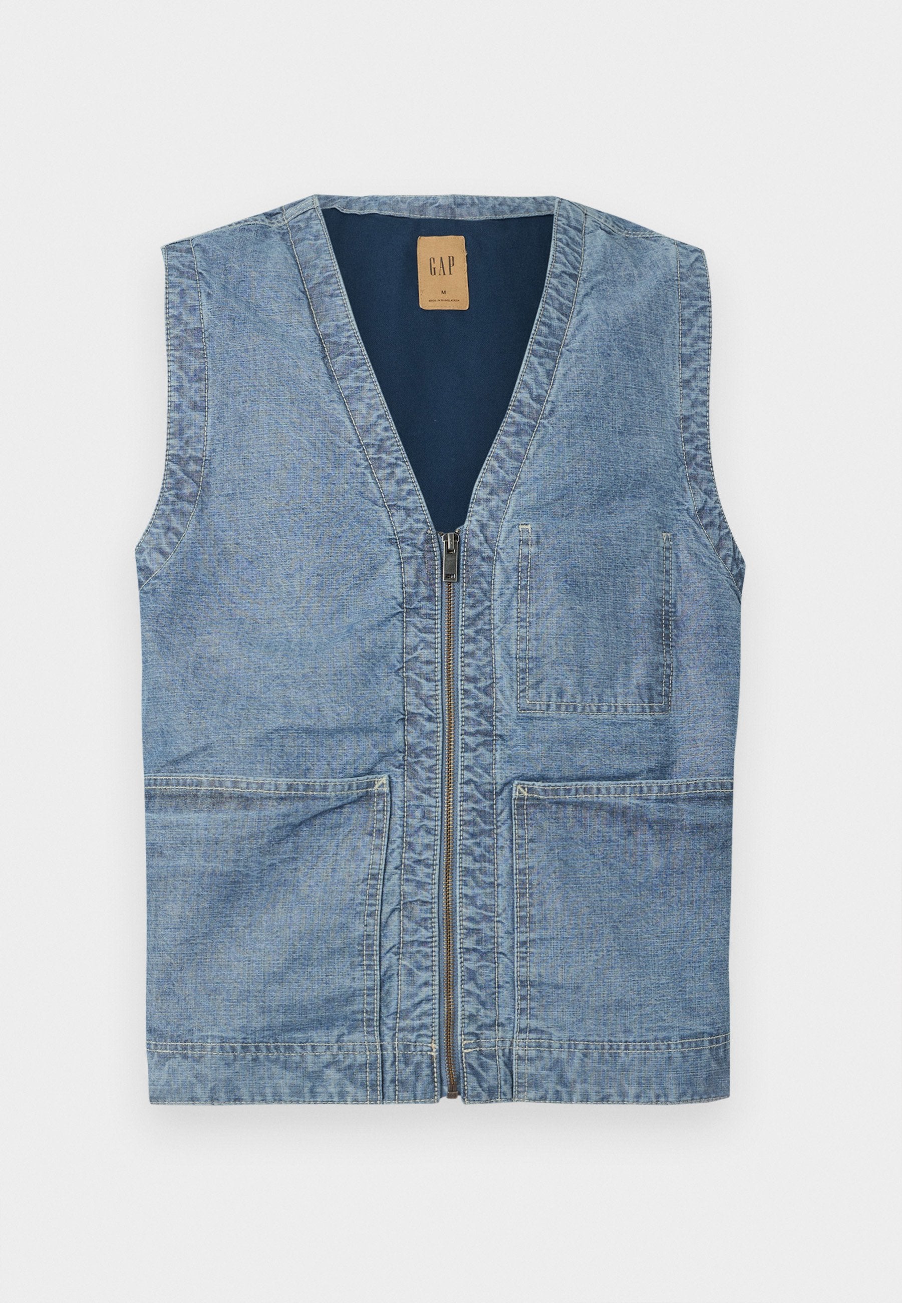 Denimweste in Hellblau mit V-Ausschnitt, Frontreißverschluss und zwei großen Fronttaschen. Schlichtes Design und strukturierter Stoff.