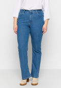 Blaue Jeans aus Denim mit geradem Bein, hoher Taille, Fronttaschen und einer dezenten, ausgewaschenen Textur. Kombiniert mit beigen Stiefeletten.