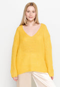 Helles gelbes Strickpullover mit V-Ausschnitt, lockerer Passform und langen Ärmeln, aus einem weichen, strukturierten Stoff und mit gerippten Details am Saum.