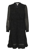 Schwarzes Kleid mit Wickeldesign, langen transparenten Ärmeln und einem gerafften Saum. Aus leichtem Stoff mit subtiler Textur gefertigt.