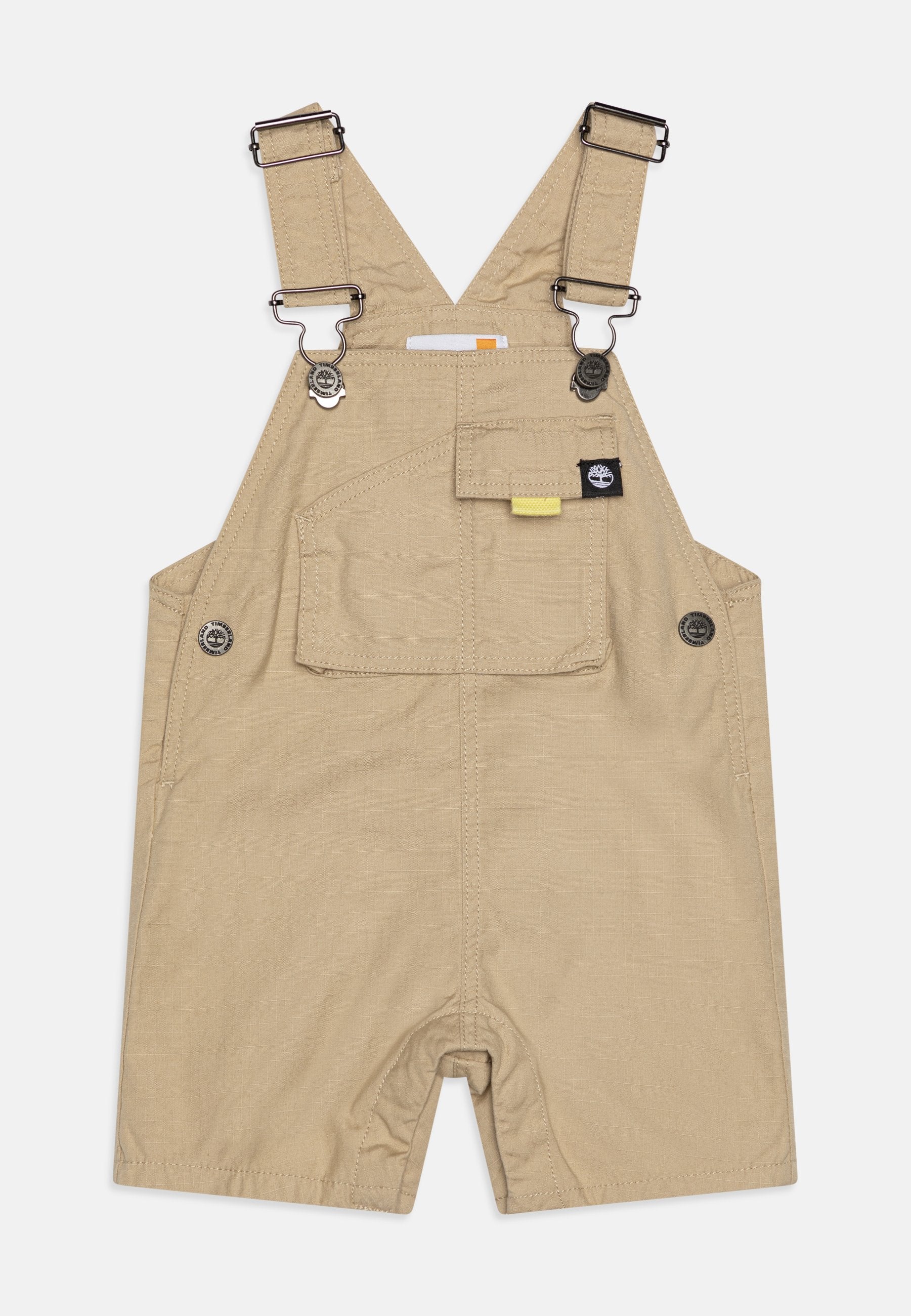 Hellebeige Latzhose aus Baumwolle mit verstellbaren Trägern, Druckknopf-Akzenten, einer Fronttasche und einer lockeren Passform, die ein offenes Bein-Design aufweist.