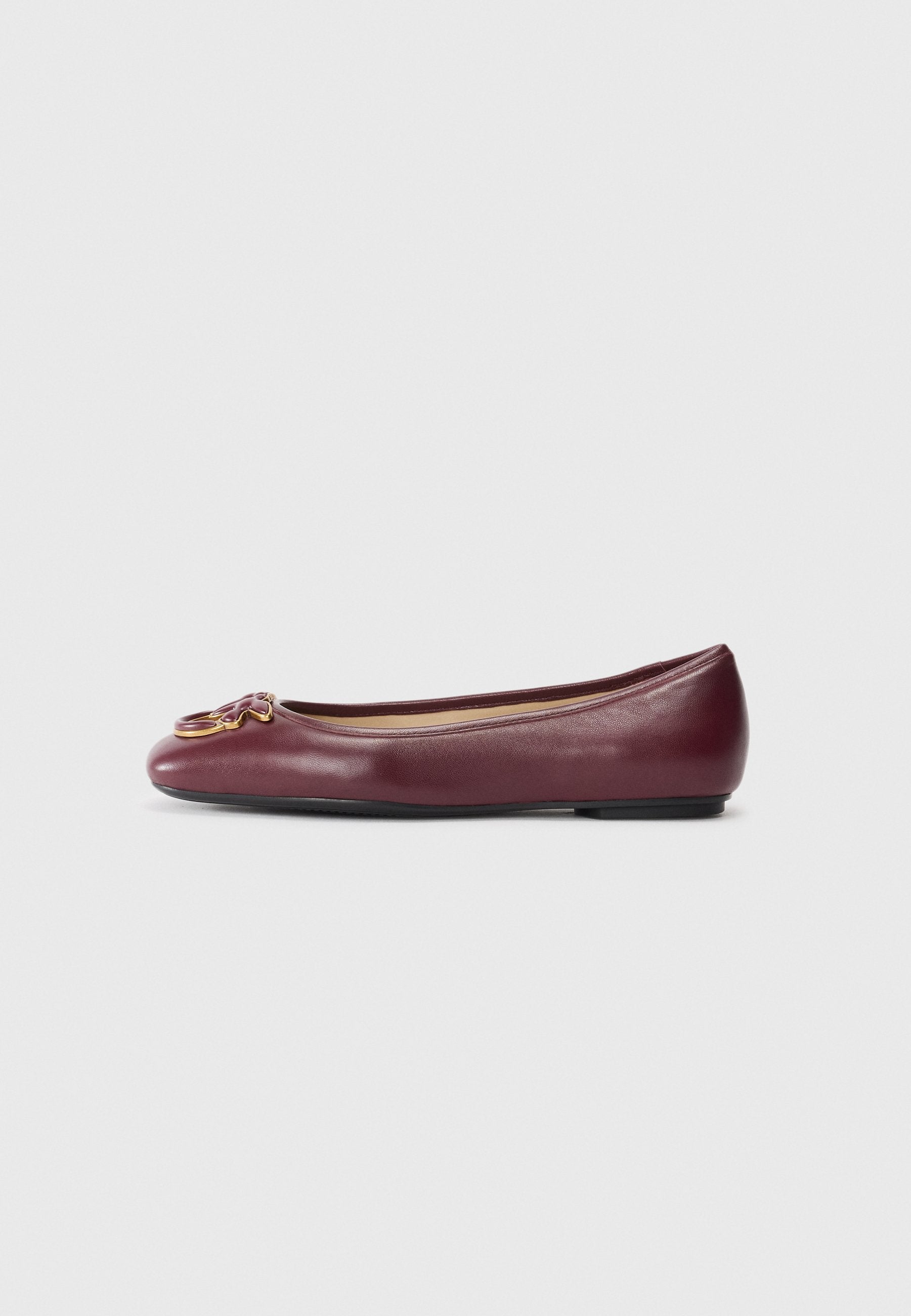 Bordeauxfarbene Leder-Balletschuhe mit rundem Zehenbereich, kleinen schwarzen Sohlen und einem dekorativen goldfarbenen Hardware-Detail an der Vorderseite.
