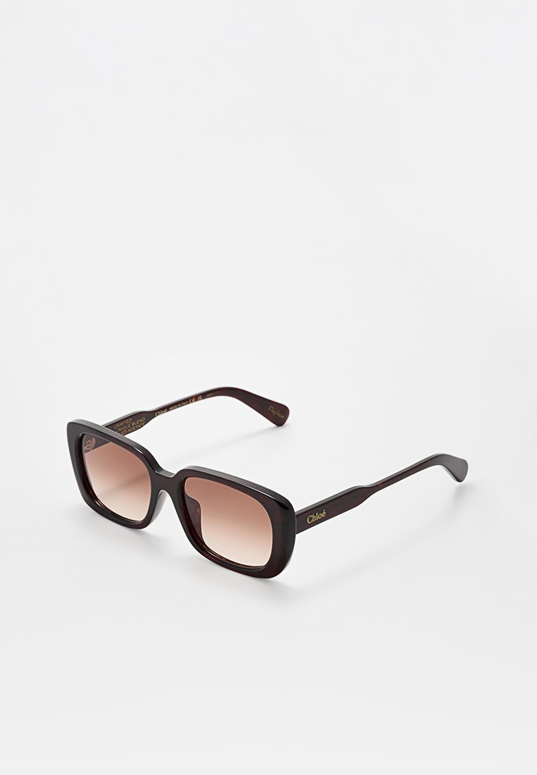 Rechteckige dunkelbraune Schildpatt-Sonnenbrille mit braunen Verlaufsgläsern und "Chloé"-Logo am Bügel vor weißem Hintergrund.