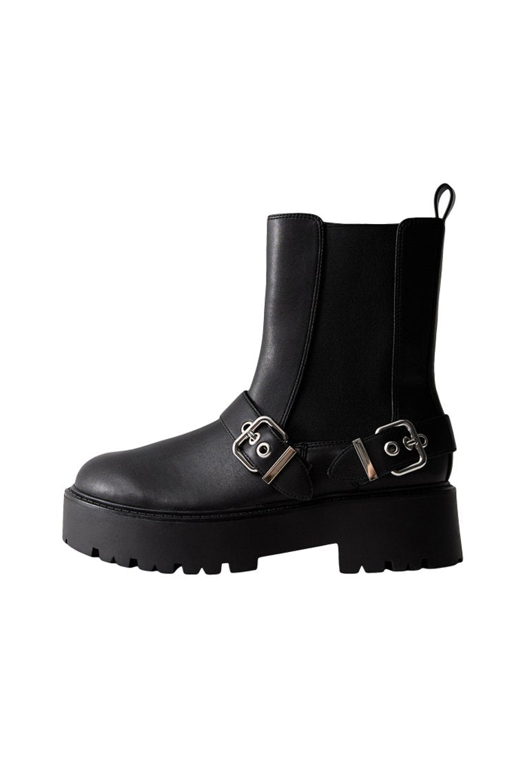 Schwarze Leder-Stiefelette mit klobiger Sohle, zwei silbernen Schnallen, elastischem Seiteneinsatz und Zugschlaufe auf der Rückseite.