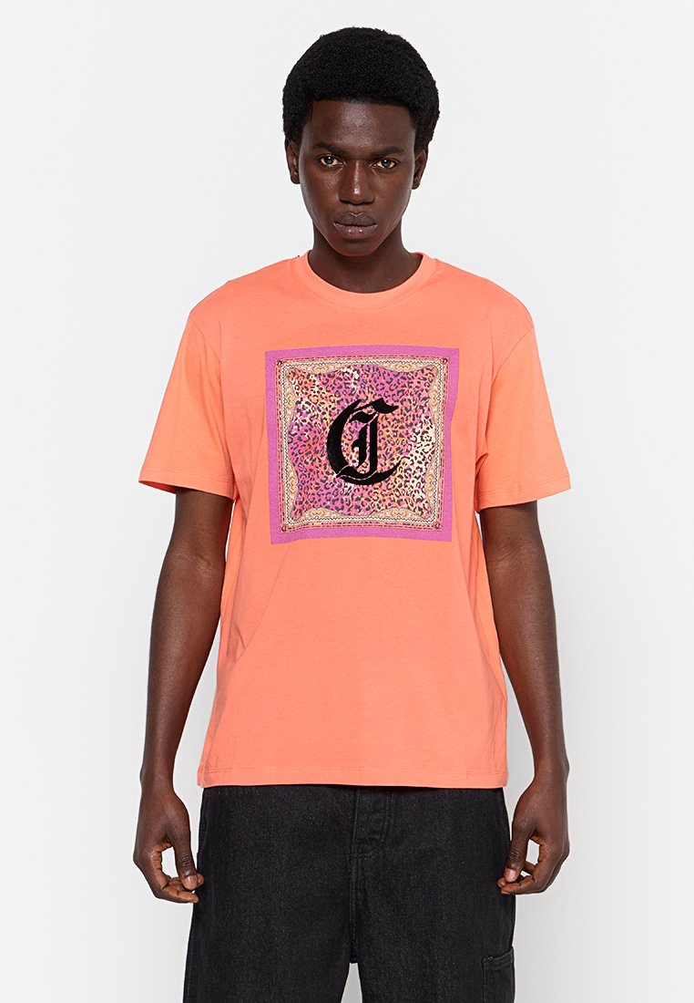 Oranges Kurzarm-Cotton-T-Shirt mit einem Leopardenmuster-Graphic, umrahmt von einem pinken und goldenen Rahmen sowie einem auffälligen schwarzen Buchstaben "C".