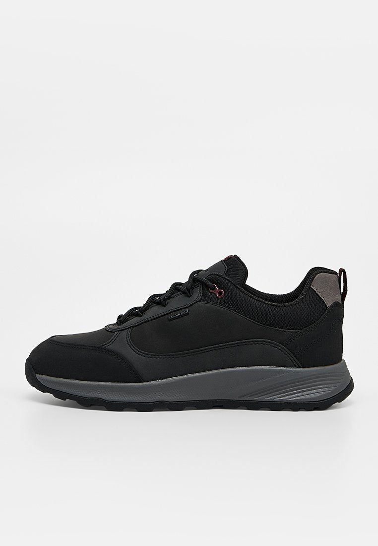 Schwarzer Low-Top-Sneaker mit grauer Sohle, Schnürung vorne, gepolstertem Kragen und Zuglasche an der Ferse, von der Außenseite gezeigt.