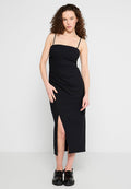 Schwarzes Midi-Kleid mit tailliertem Oberteil, schlanken Trägern und einem schulterhohen Seitenschlitz. Hergestellt aus glattem Textil mit einem dezenten Fall.