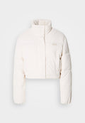 Gekürzte, puffige Jacke aus off-weißem Cord. Verfügt über einen hohen Kragen, Druckknöpfe und dezente Logodetails auf der Brust.