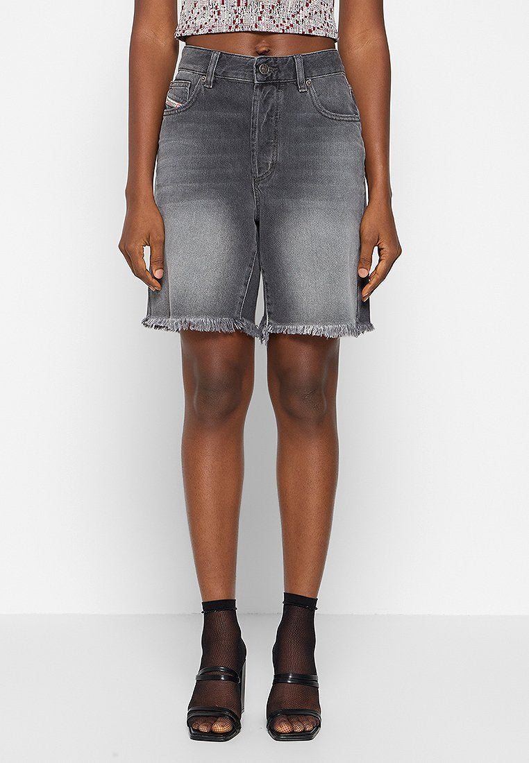 Graue Denim-Shorts mit ausgefranstem Saum, zwei vorderen Taschen und einem ausgewaschenen Look. Kombiniert mit schwarzen Absatzsandalen und einem gemusterten Crop-Top.
