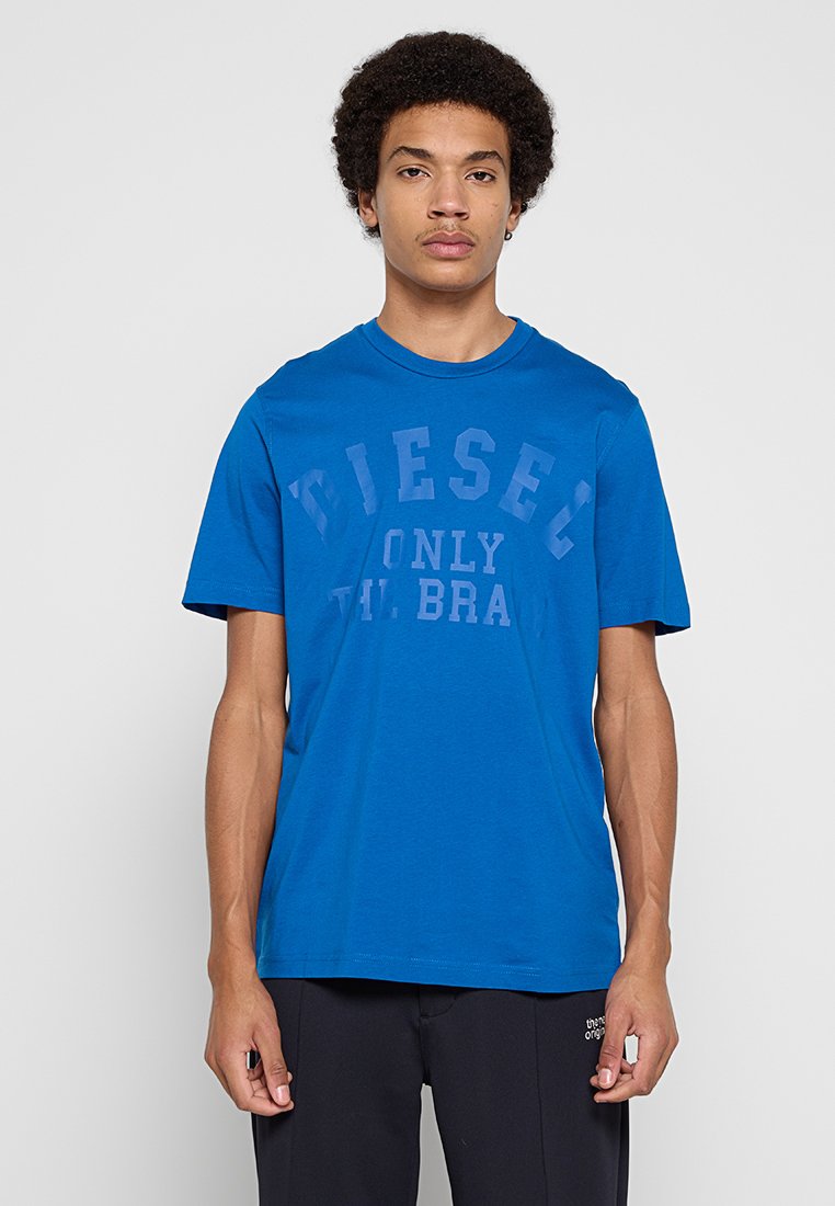 Blaues Baumwoll-T-Shirt mit rundem Ausschnitt und kurzen Ärmeln, mit einem großen, im Siebdruckverfahren aufgebrachten Logo in dunklerem Blau mit der Aufschrift "DIESEL ONLY TH BRA".