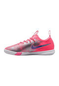 Flacher Indoorsoccer-Schuh mit pink-silbernem Obermaterial, lila Nike-Swoosh, Schnürverschluss und weißer Sohle.