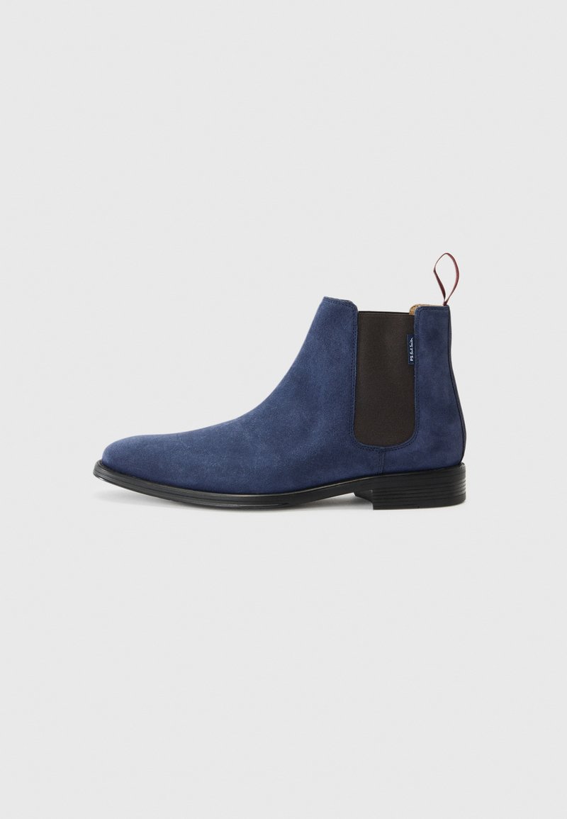 Marineblaues Wildleder-Ankle-Boot mit elastischen Seitenpaneelen, einem Ziehhilfe, abgerundetem Zehenbereich und einer schwarzen Gummisohle. Glatte Textur mit minimaler Verzierung.