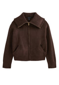 Brauner Fleece-Zip-Jacke mit großem Kragen, zwei Fronttaschen und goldenen Reißverschlussdetails. Weiche Textur, verkürztes Design.