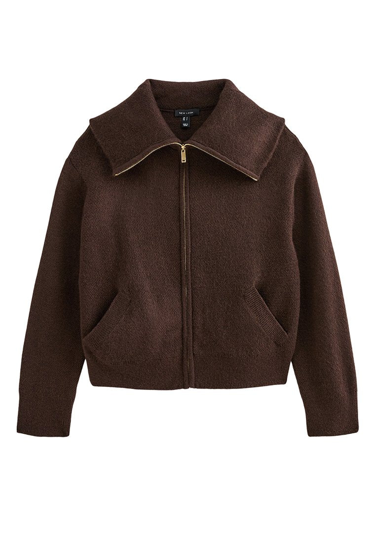 Brauner Fleece-Zip-Jacke mit großem Kragen, zwei Fronttaschen und goldenen Reißverschlussdetails. Weiche Textur, verkürztes Design.
