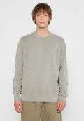 Hellgrüner Rundhals-Pullover mit langen Ärmeln, gerippten Bündchen und Saum. Verfügt über eine subtile Textur und ein Logo am linken Ärmel.