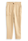 Beige Hose mit lockerer Passform, aus weichem Stoff gefertigt. Merkmale sind zwei Fronttaschen, ein Knopfverschluss und ein elastischer Bund.