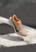 Nike-Laufschuh mit atmungsaktivem Mesh-Obermaterial in Hellgrau und Orange, mit schwarzem Swoosh-Logo und einer gepolsterten weißen Sohle.