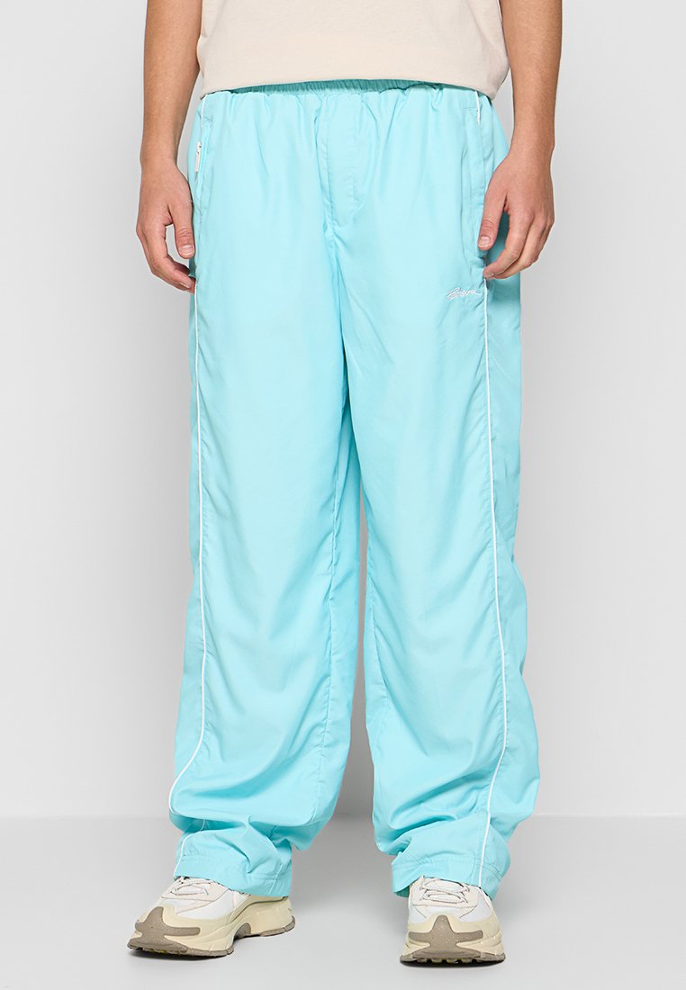 Hellblaue, leichte Jogginghose mit elastischem Bund, Seitentaschen, weißen Paspeln und gesticktem Logo-Detail. Geeignet für Freizeitbekleidung.