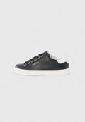 Schwarzer Ledersneaker mit weißer Ferse, goldenen Ösen, weißer Sohle und „AIGNER“-Logo an der Seite, im Seitenprofil vor grauem Hintergrund gezeigt.