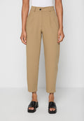 Beige, hoch taillierte, schmal zulaufende Hose mit Falten, Knopfverschluss, getragen mit schwarzen offenen Sandalen mit Blockabsatz und einem weißen Oberteil.